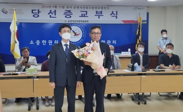 순천시산림조합장 보궐선거에 당선된 서용석(오른쪽) 후보가 축하 꽃다발을 들고 박남천(광주지법 순천지원장) 순천시선거관리위원회 위원장과 기념사진을 찍고 있다.